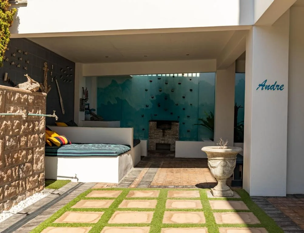 Modern bedroom with bed, climbing wall, and indoor-outdoor design