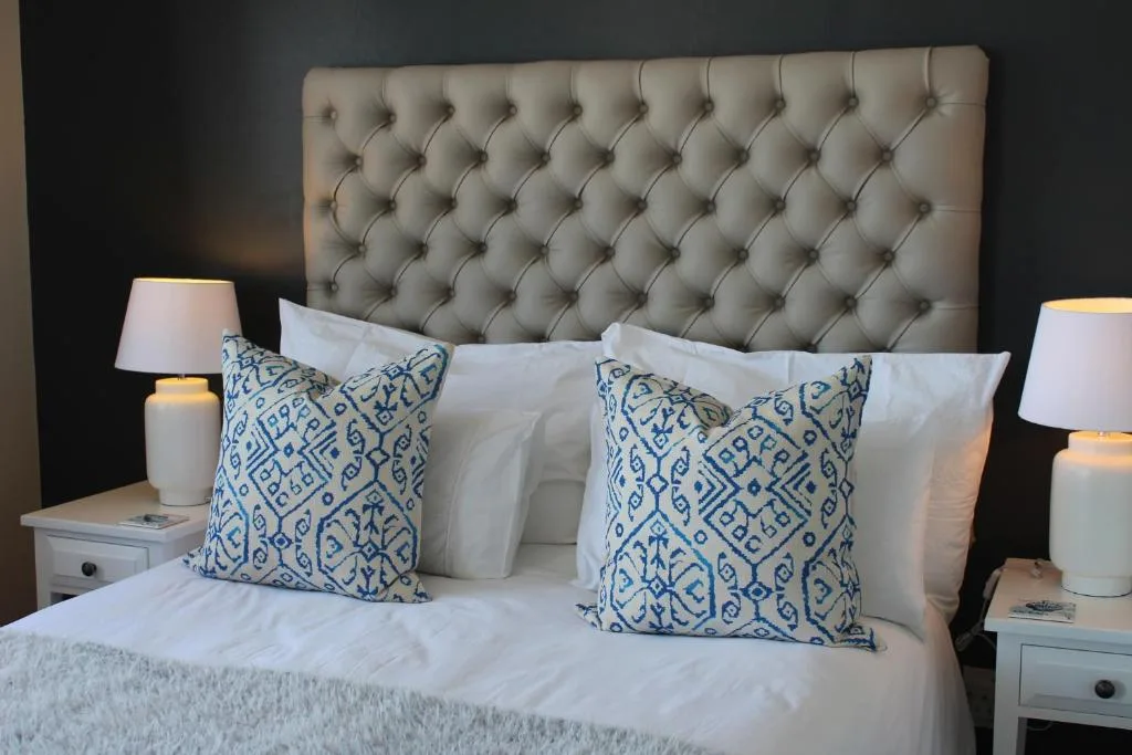 Elegantly styled bedroom with tufted headboard and blue patterned pillows