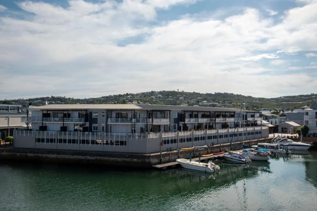 Modern waterfront apartment building with boats moored at private jetty