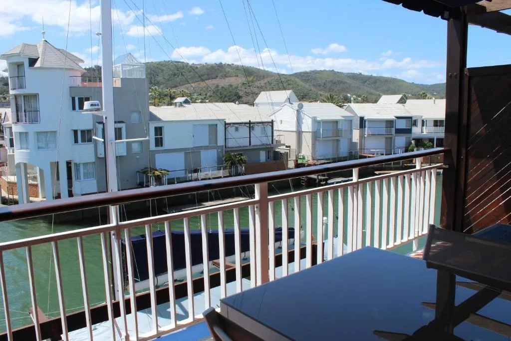Waterfront view of Knysna lagoon with hillside and neighboring properties