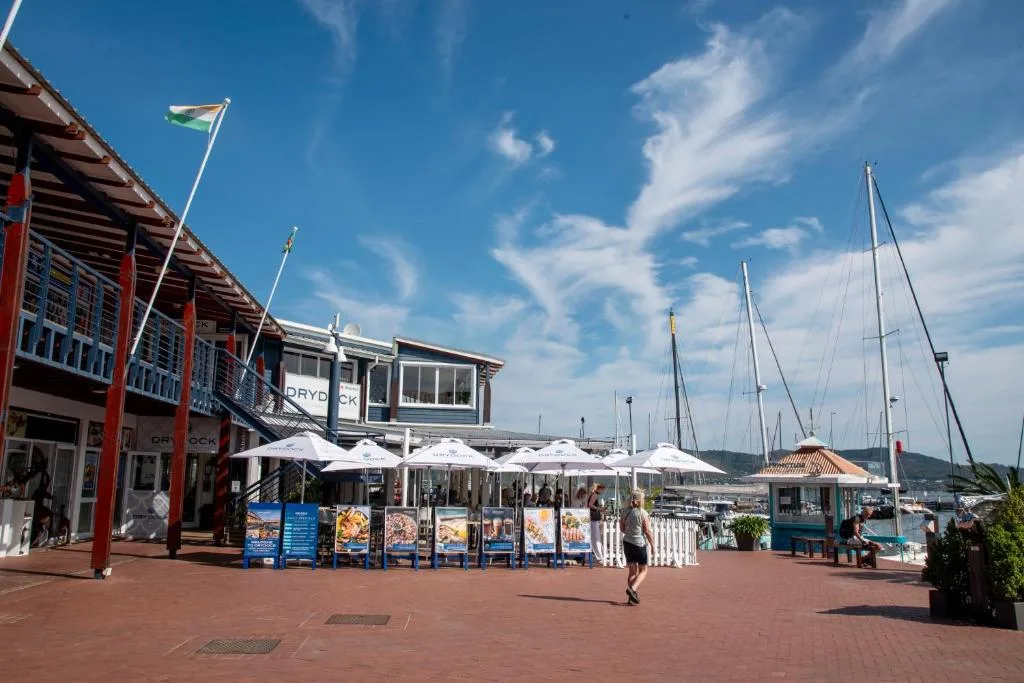 Waterfront promenade with sailing boats and harbor district restaurants