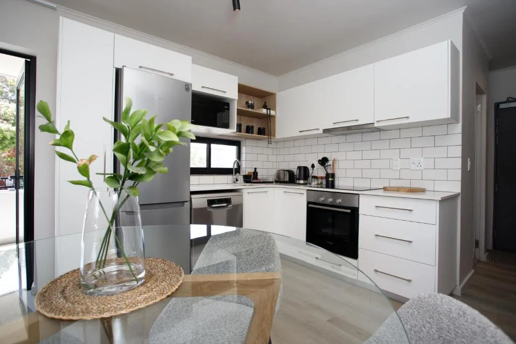 Modern white kitchen with stainless steel appliances and subway tile backsplash