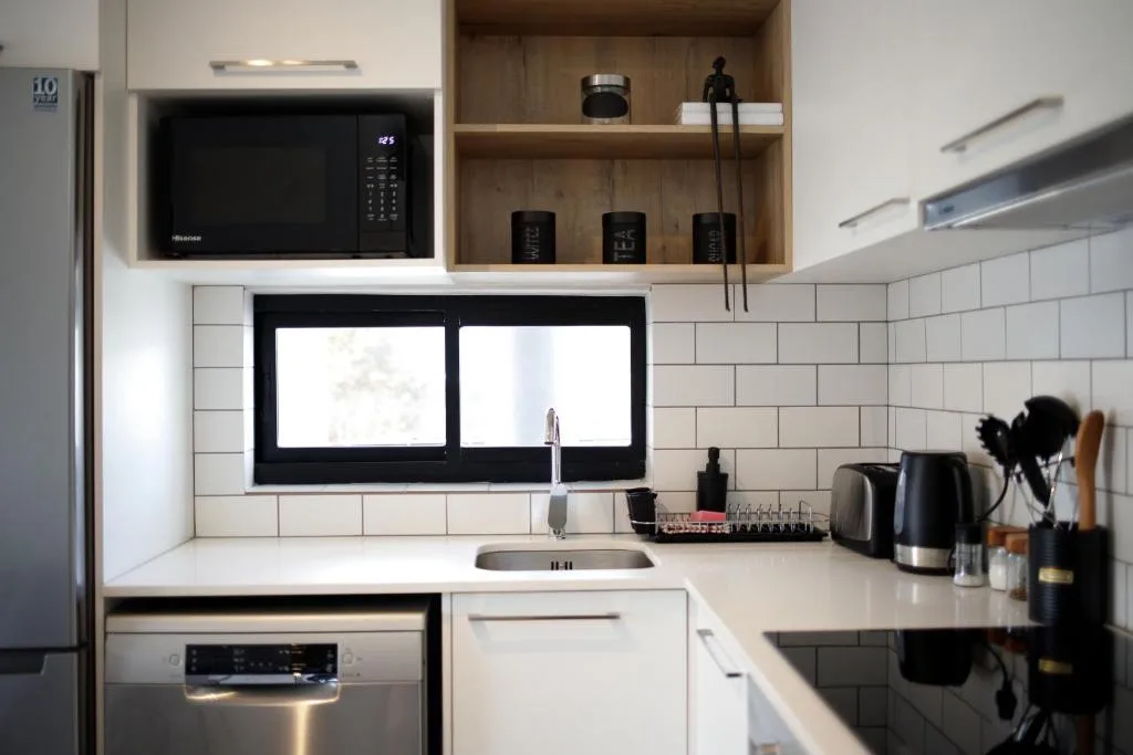 Modern kitchen with white cabinetry, subway tile backsplash, and stainless steel appliances