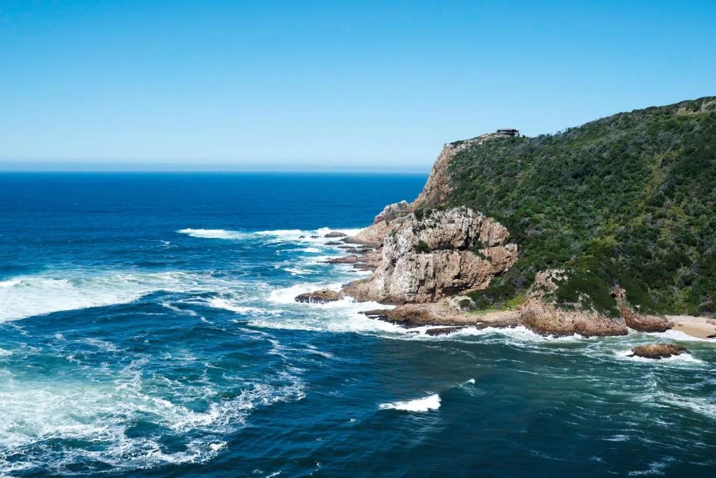 Dramatic coastal cliffs with turquoise ocean waves and pristine beach
