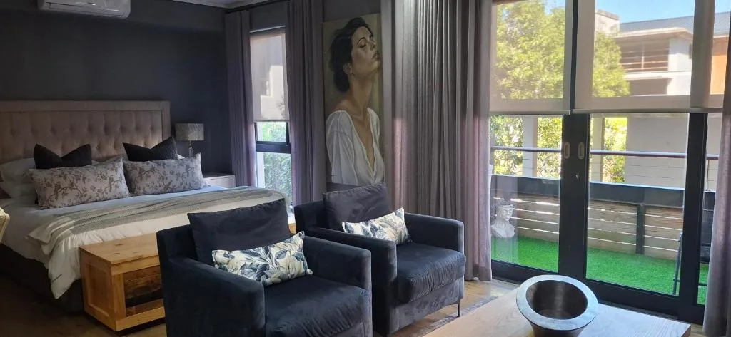 Luxury bedroom with bed, seating area, and sliding doors to deck