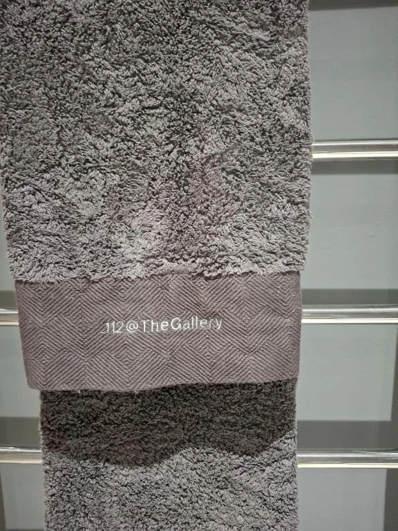 Close-up of plush gray towels stacked neatly against white shelving