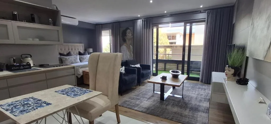 Modern lounge with sofa, coffee table, and open-plan kitchen area