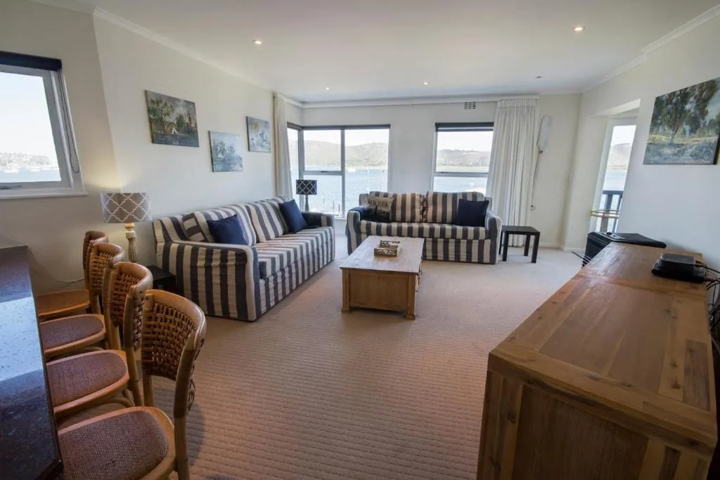 Spacious lounge with striped sofas and water views through large windows