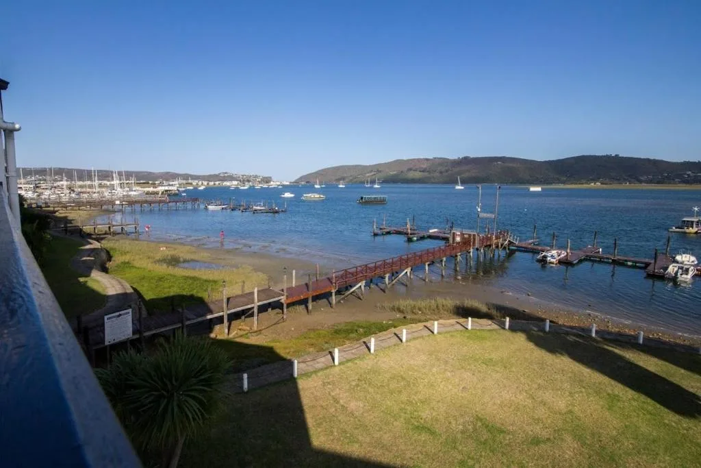 Knysna Heads marina with sailboats, docks, and lagoon waters beyond