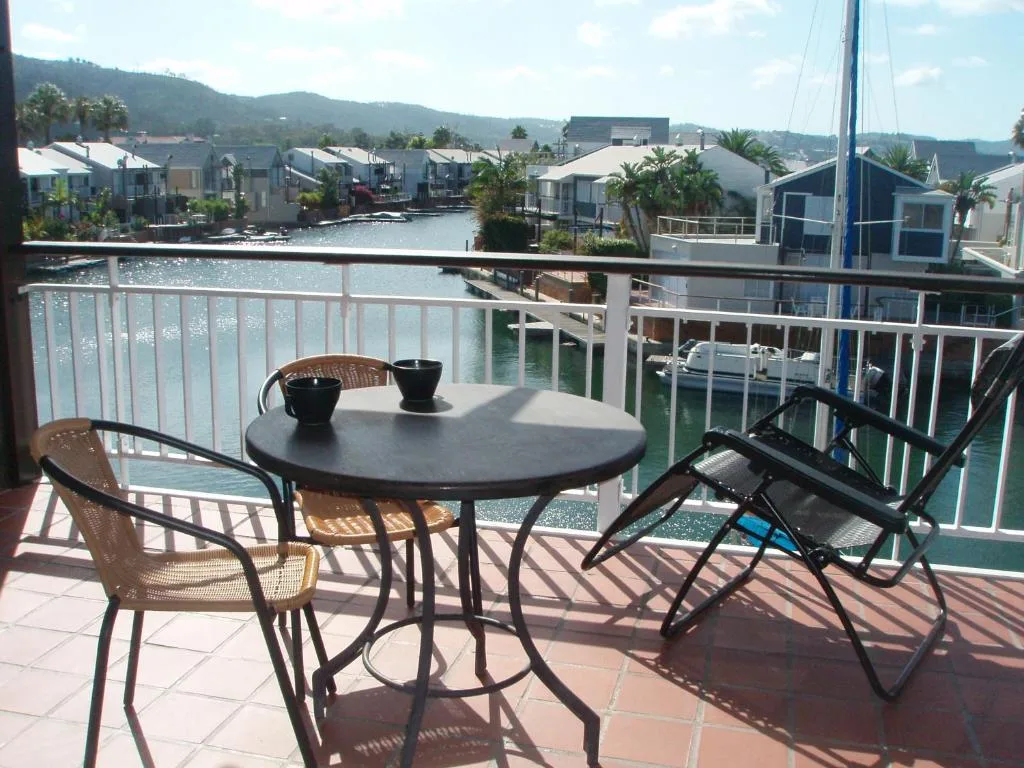 Waterfront deck with dining table overlooking Knysna lagoon and houseboats