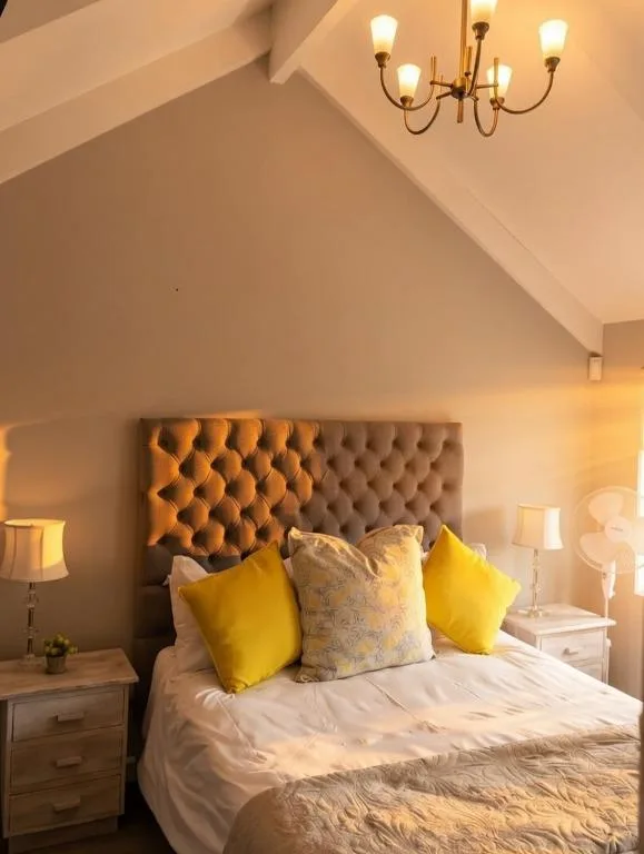 Bright bedroom with upholstered headboard and cheerful yellow accent pillows