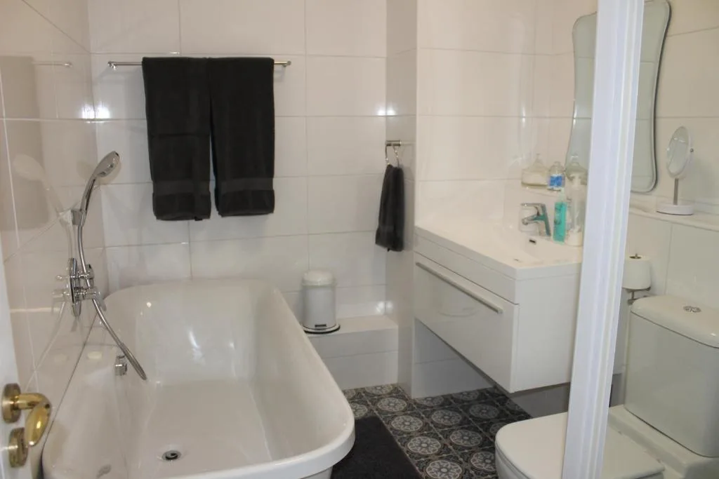 Clean bathroom with freestanding bathtub, vanity sink, and toilet