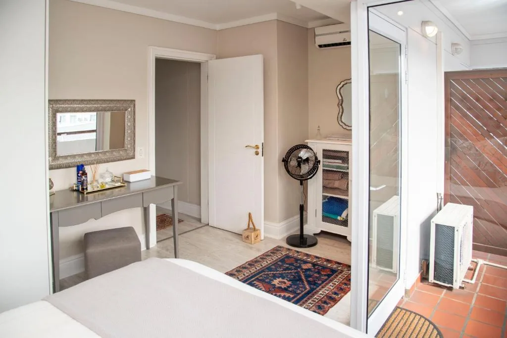 Spacious bedroom with vanity desk, mirror, and access to outdoor deck area