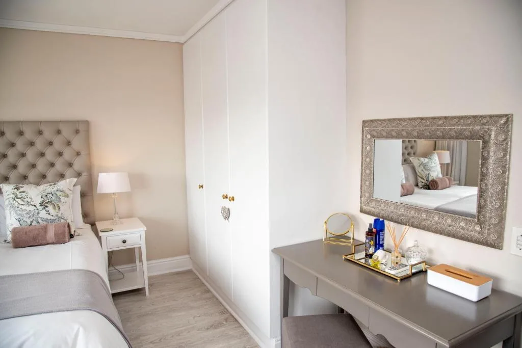 Elegantly styled bedroom with upholstered headboard and vanity mirror