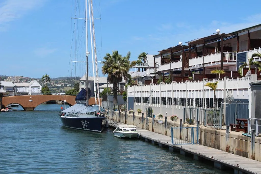 Waterfront apartment building with sailboat moored at private dock