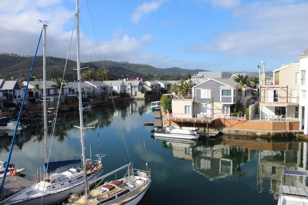 Scenic waterfront view of Knysna harbour with sailboats and mountains
