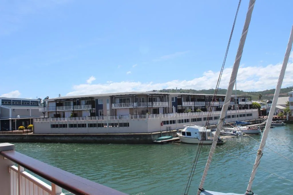 Waterfront apartment building overlooking Knysna lagoon with moored sailboats