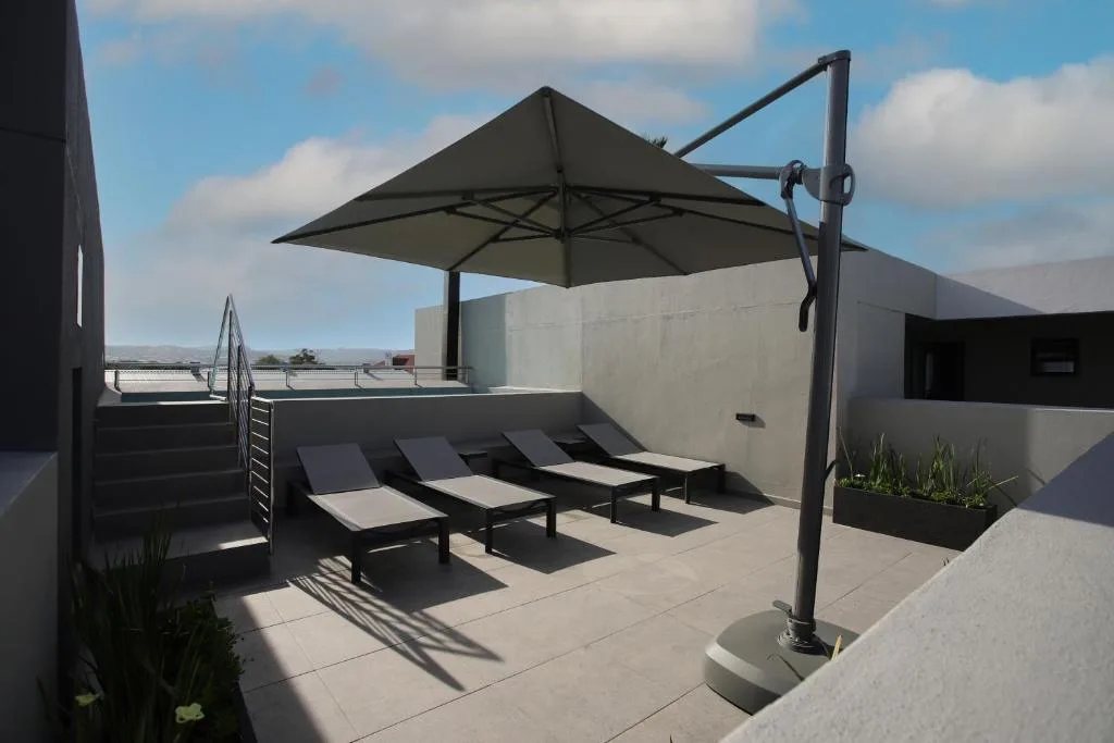 Modern rooftop deck with loungers and black cantilever umbrella