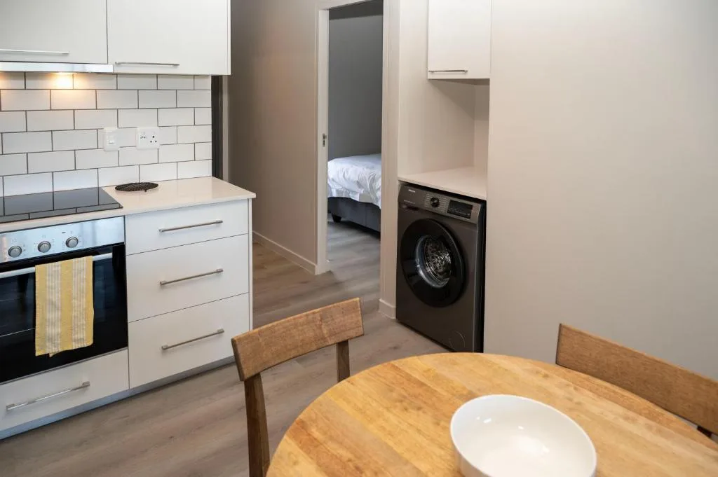 Modern kitchen with white cabinetry, stove, and washing machine visible