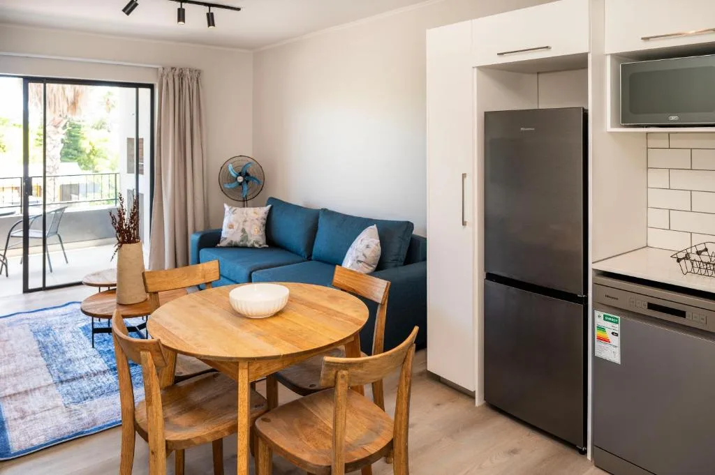 Open-plan lounge and dining area with blue sofa and wooden table
