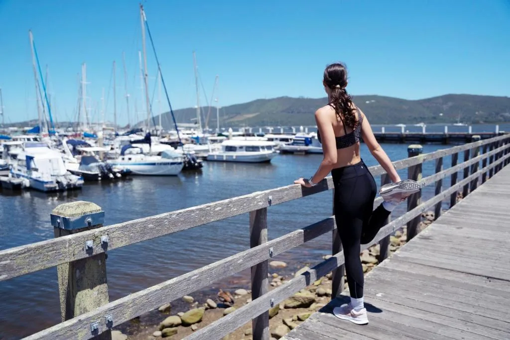 Woman overlooking Knysna marina with sailboats and mountains beyond