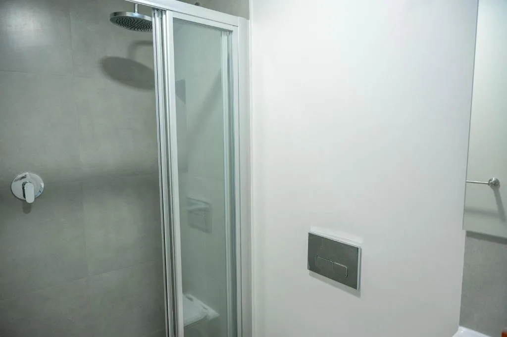 Modern shower enclosure with rainfall showerhead and glass sliding door