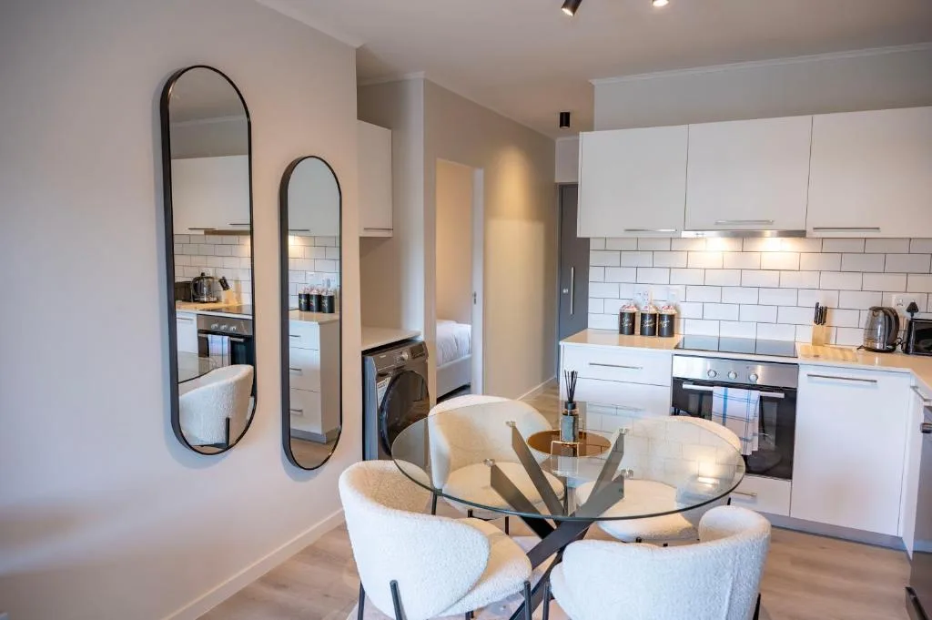 Modern white kitchen with subway tile backsplash, black oven, and dining area
