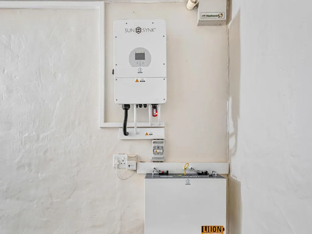 Solar power inverter and battery system mounted on white wall