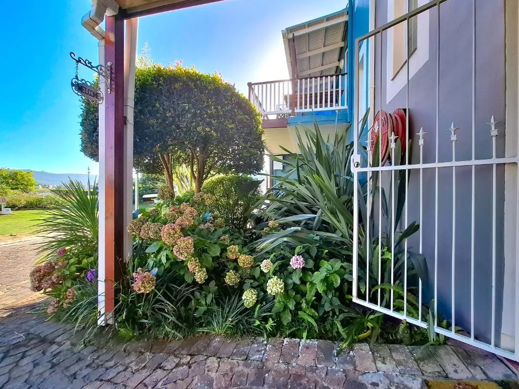 Colorful entrance with lush flowering garden and mountain views beyond