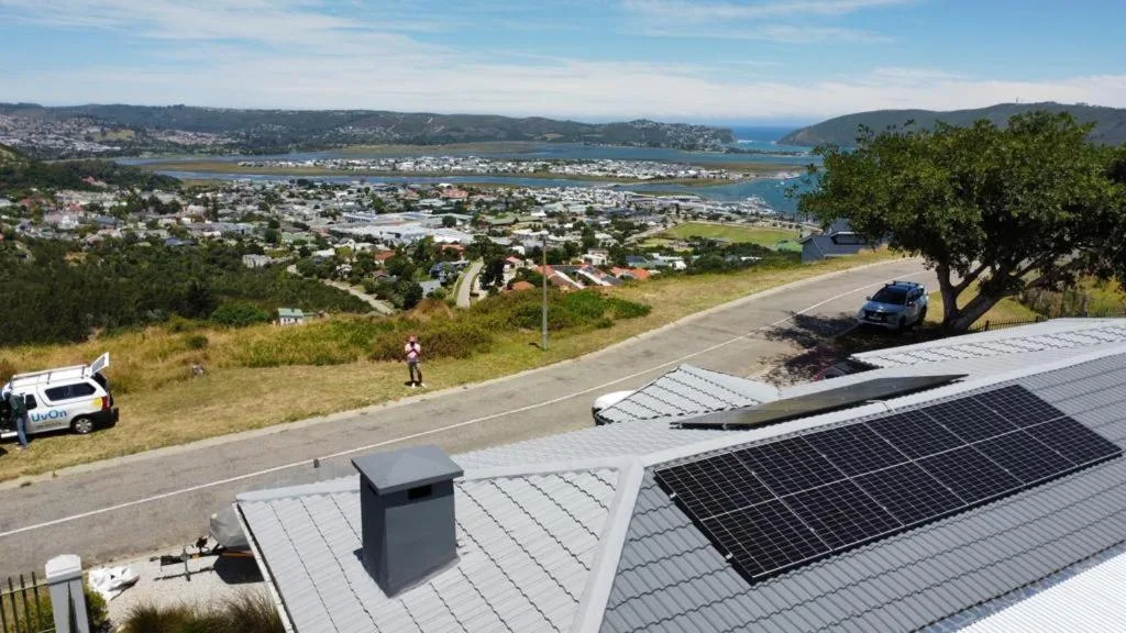 Panoramic coastal town view from hilltop property overlooking lagoon and mountains