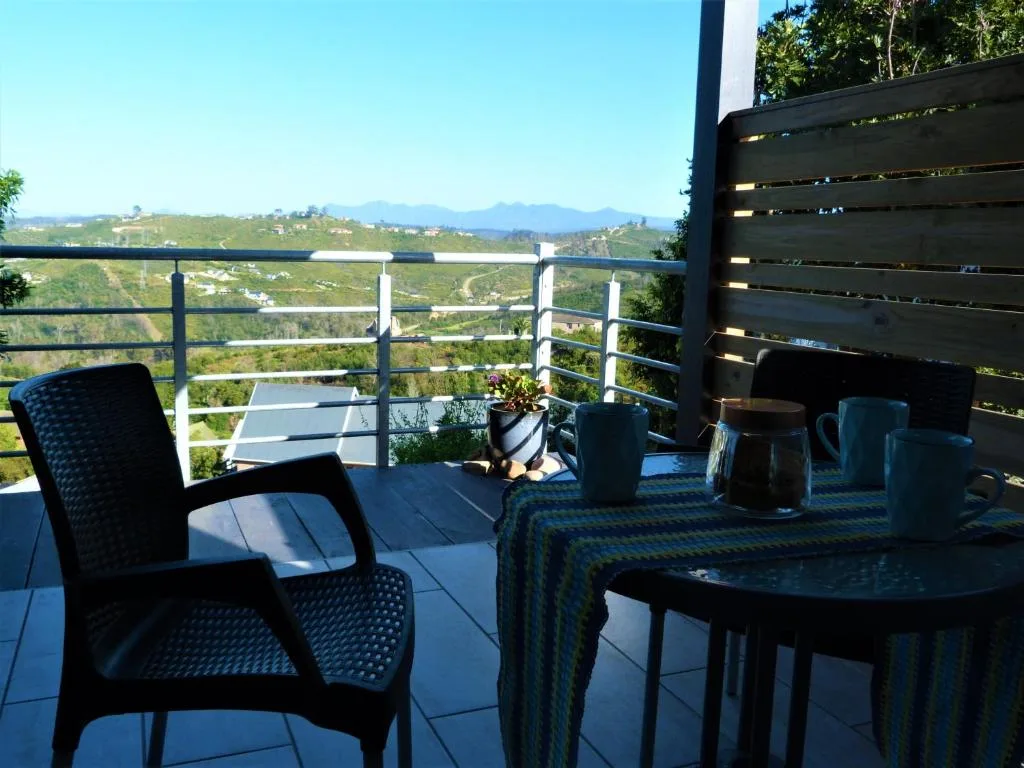 Panoramic vista of rolling green hills and distant mountains from elevated deck