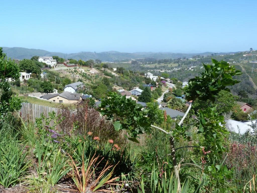 Scenic valley landscape with mountains, scattered houses, and lush vegetation