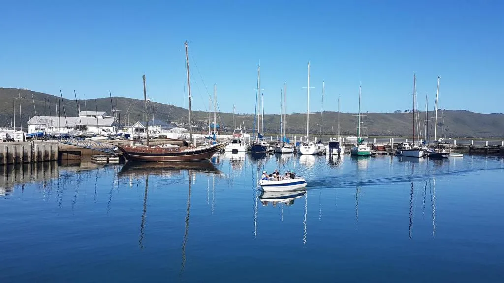 Tranquil harbor with sailboats and mountains in background
