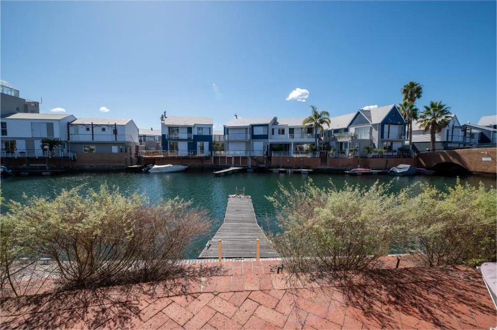 Waterfront view of colorful boathouses and wooden jetty in Knysna lagoon