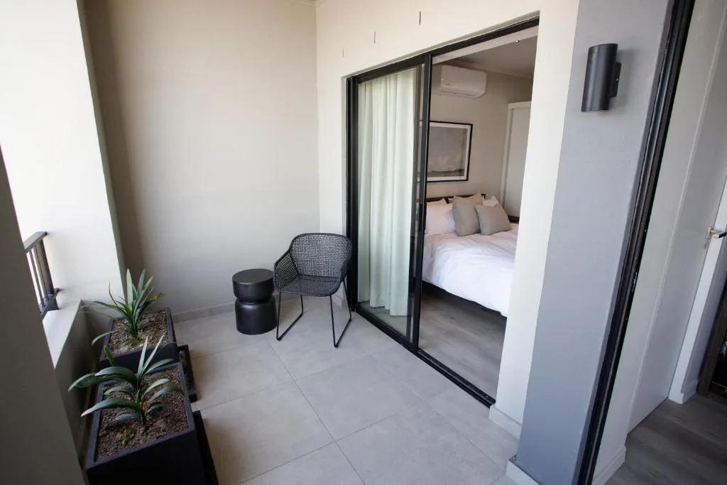 Modern patio area with chair, plants, and sliding glass bedroom doors