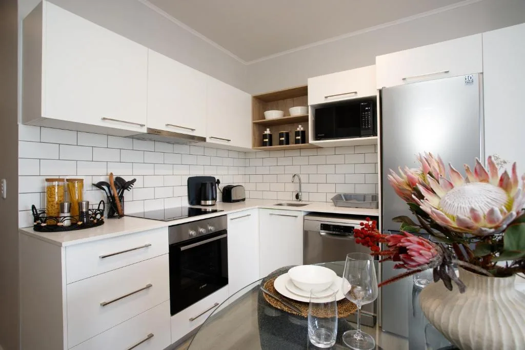 Modern white kitchen with stainless steel appliances and subway tile backsplash