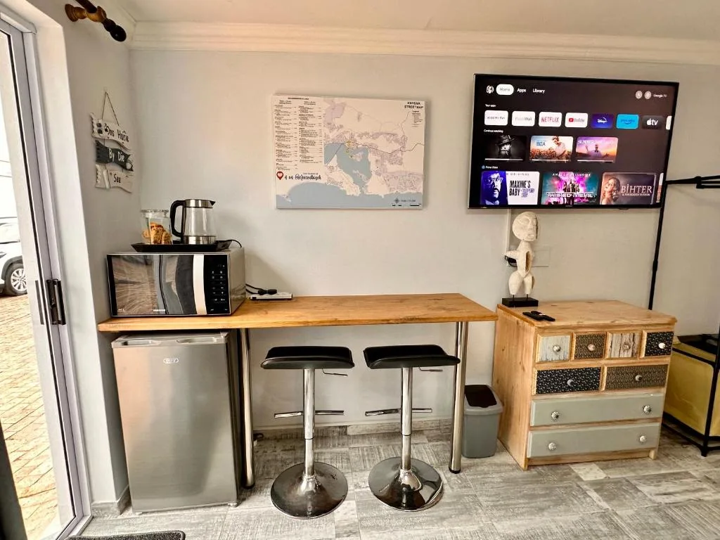 Modern lounge area with TV, bar seating, microwave and mini-fridge