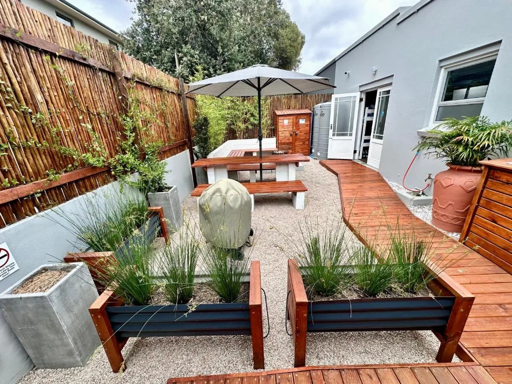 Outdoor patio with wooden decking, umbrellaed seating, and raised planters