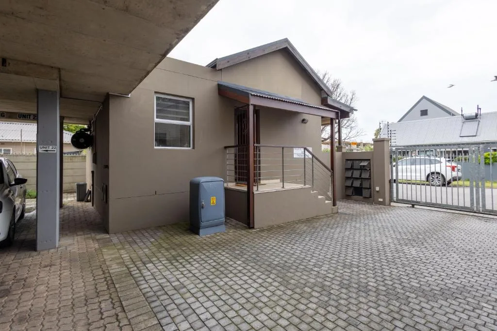 Modern beige apartment building with dark trim and secure gated entrance courtyard