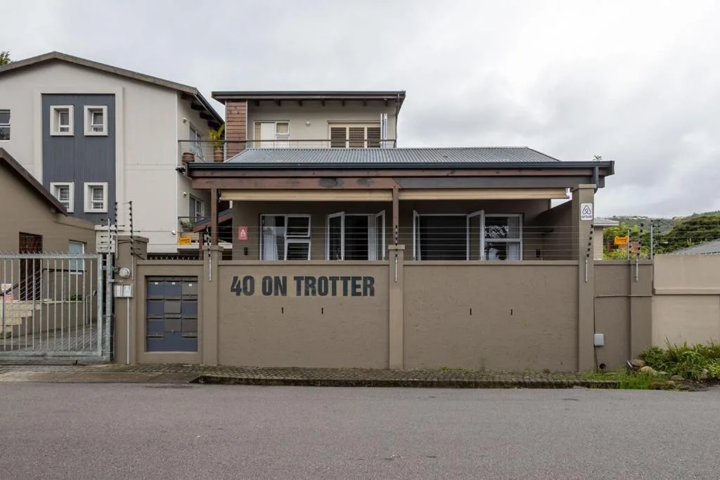 Modern beige townhouse with dark roof and covered entrance porch