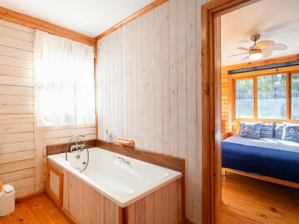 Wooden bathroom with soaking tub and vintage brass fixtures