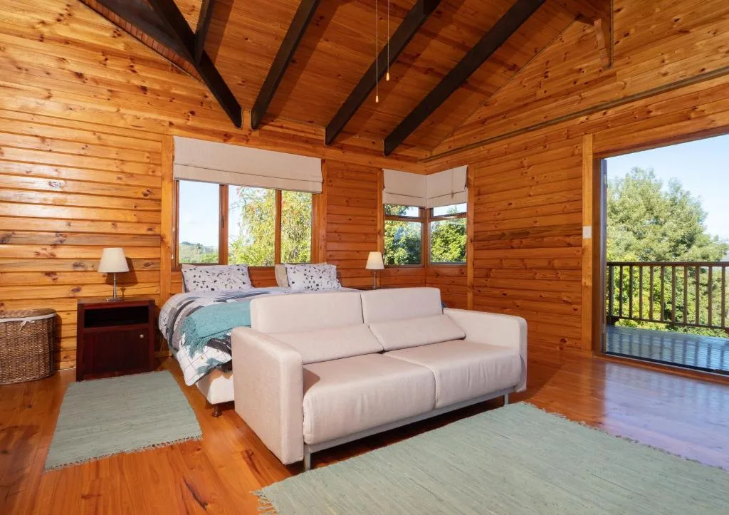 Spacious wooden lodge lounge with cream sofa and garden views