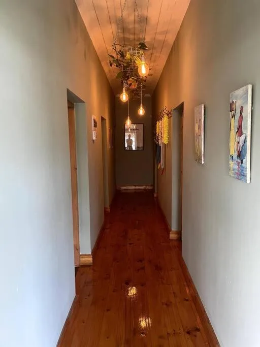 Long hallway with wooden floors and decorative hanging pendant lights