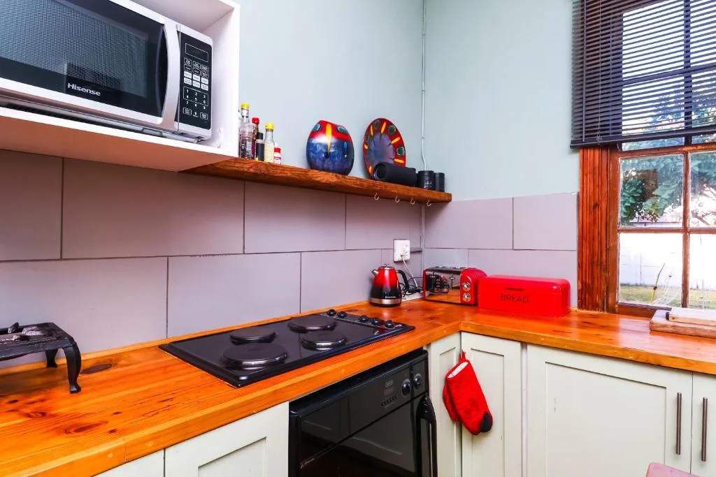 Modern kitchen with wooden counters, black stove, and pink tiling