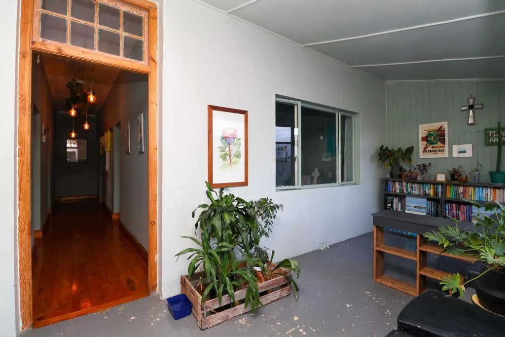 Open-plan living space with bookshelves, plants, and pendant lighting fixtures