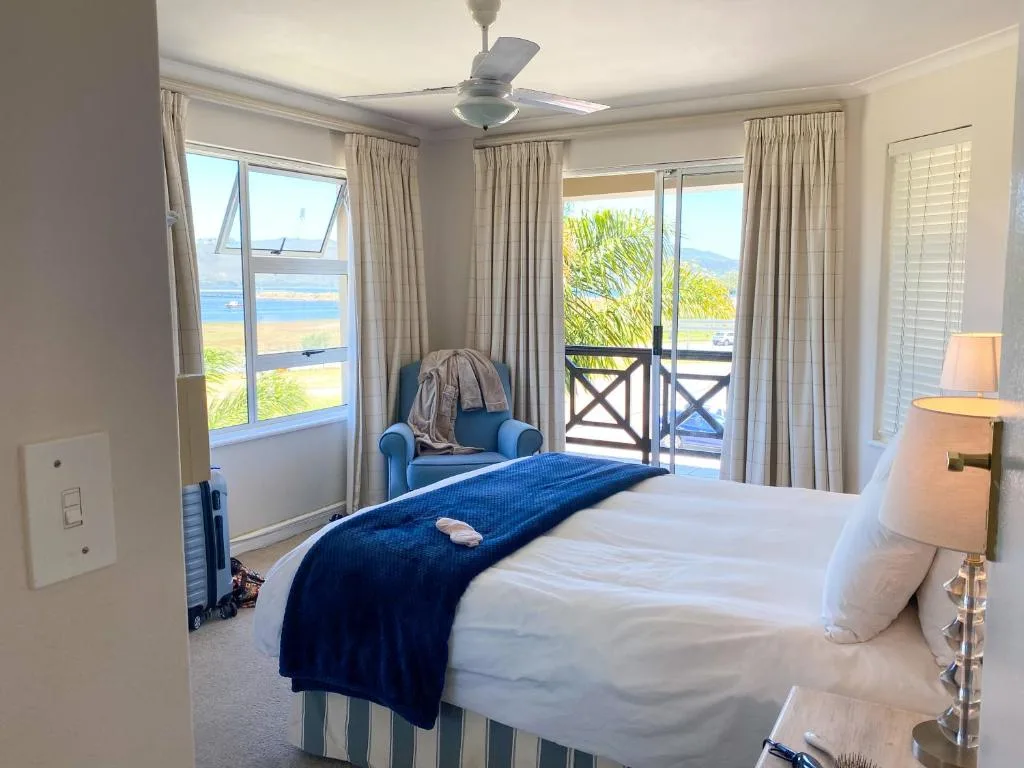 Bright bedroom with ocean view through large glass doors and windows