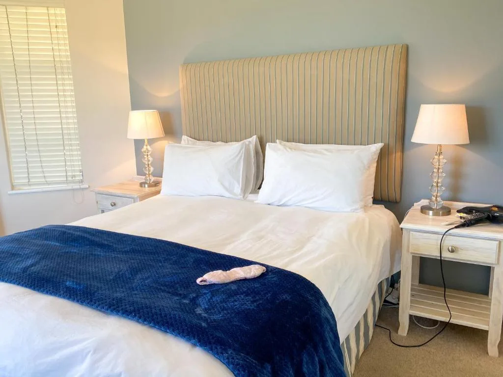 Elegantly appointed bedroom with striped headboard and white bedding