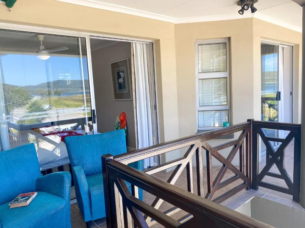 Spacious balcony with blue chairs overlooking Knysna lagoon and mountains