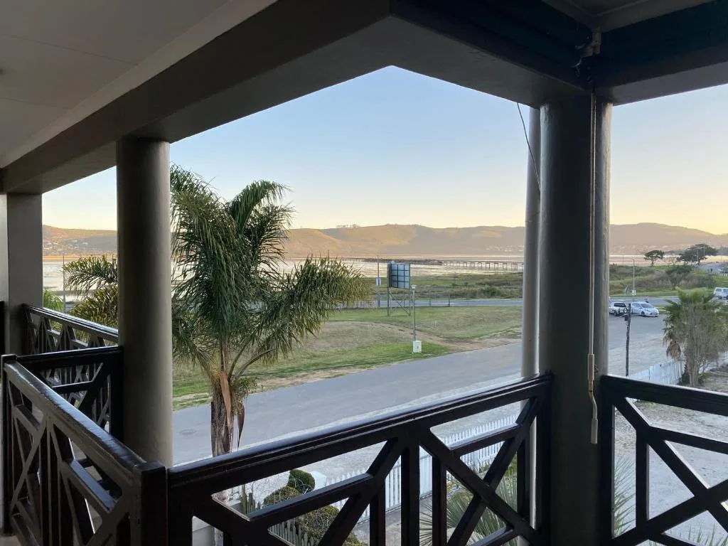 Scenic lagoon and mountain views from covered balcony with palm tree