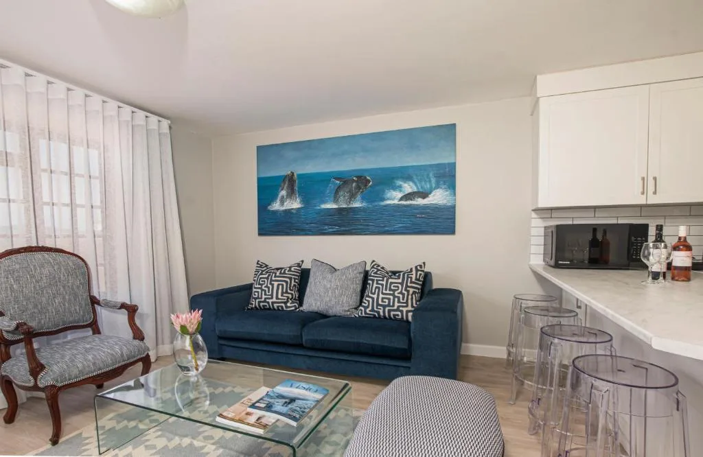 Modern living room with navy sofa, whale artwork, and ocean-themed decor